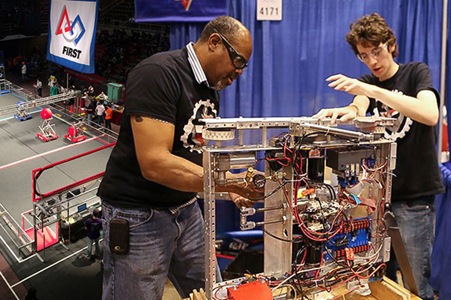Teacher and student working on robot