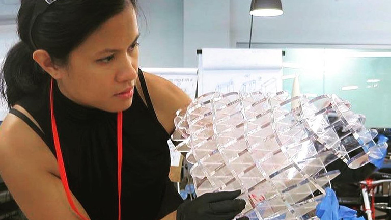 Une créatrice travaillant sur un projet avec des formes géométriques en verre transparent