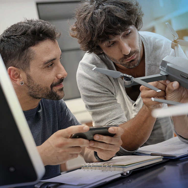 Two startup employees working on a drone