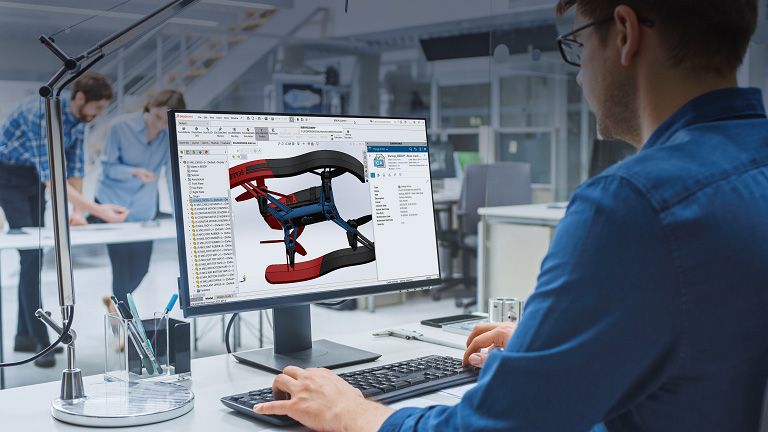 Progettista che utilizza SOLIDWORKS su schermo per il settore high-tech