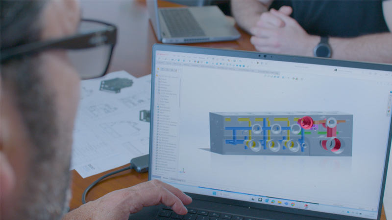 ノートパソコンでSOLIDWORKSの3Dモデルを使って作業をしている設計者