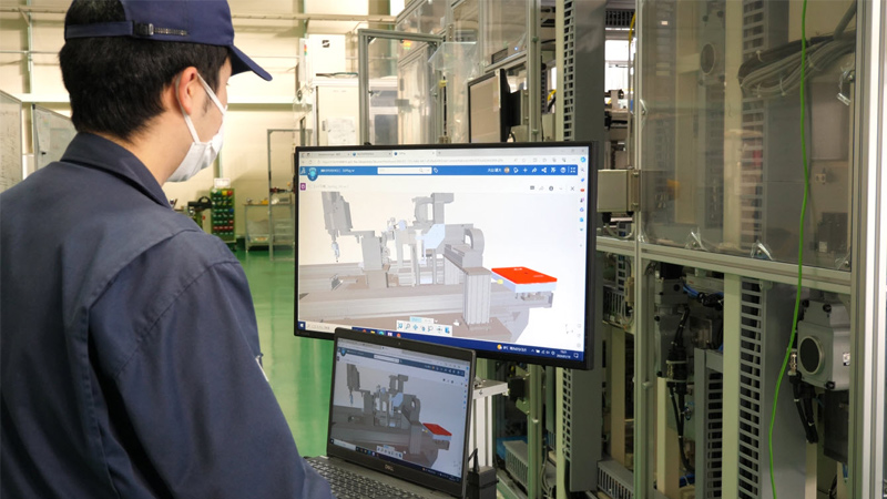 车间员工查看屏幕上显示的工业机器 SOLIDWORKS 3D 模型