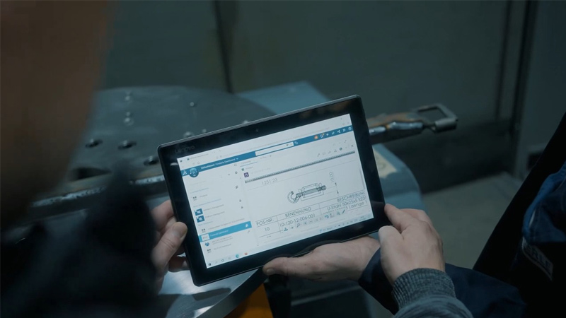 车间员工查看平板电脑上显示的 SOLIDWORKS 零件工程图
