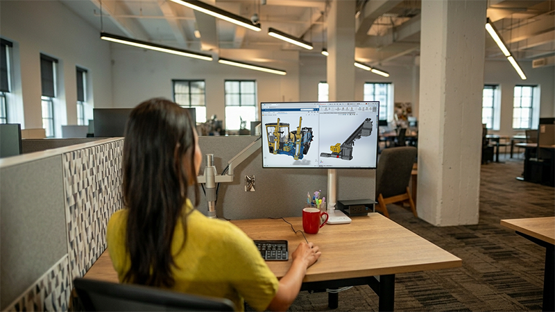 mechanical design engineer using solidworks design software on a desktop monitor to view and edit an industrial heavy equipment model