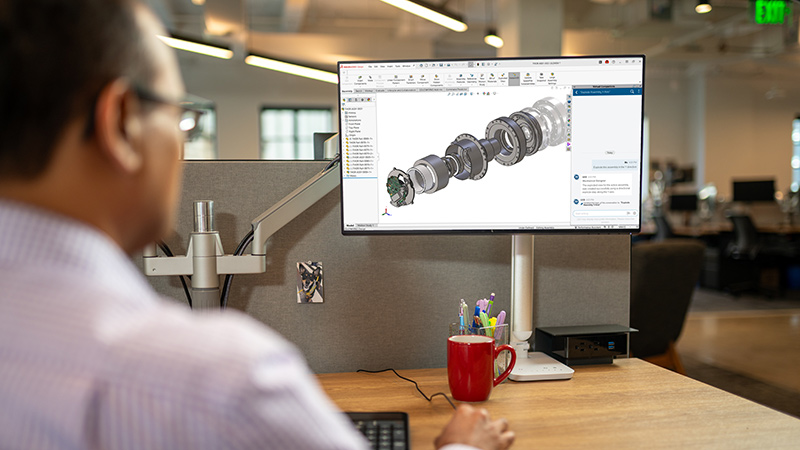 Man in office designing 3D model with SOLIDWORKS AI