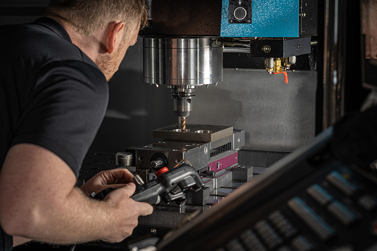 Mann, der eine CNC-Maschine bedient – 3DEXPERIENCE SOLIDWORKS for Makers