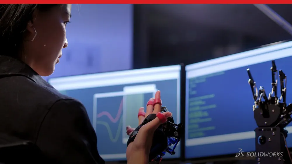 Young woman comparing a robotic arm to the design on her screen