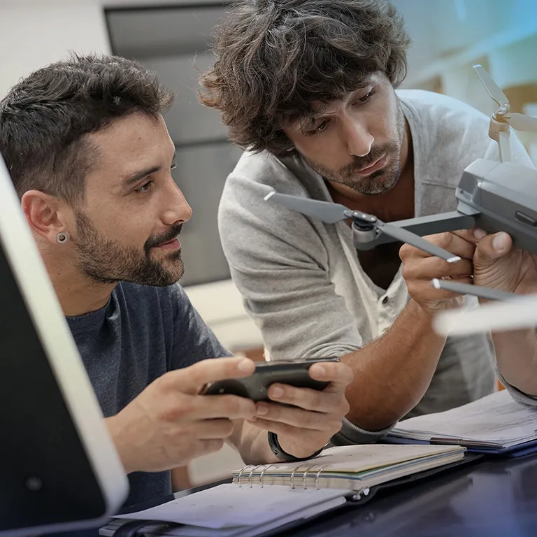 Two startup employees working on a drone