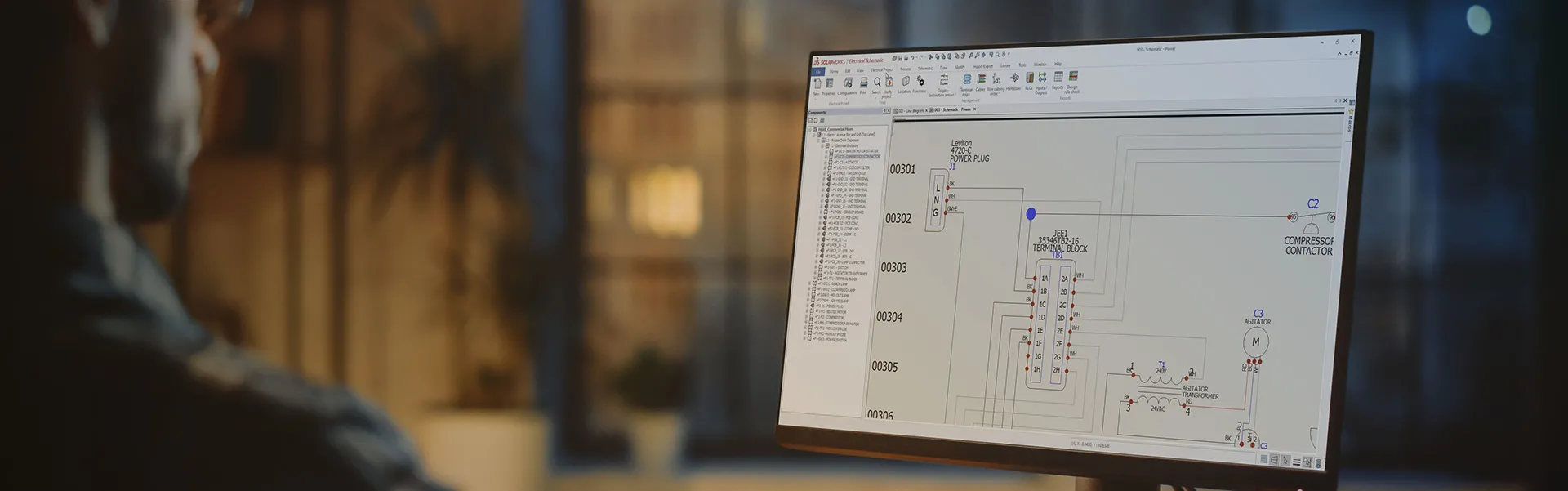 Hombre mirando una pantalla con un diseño esquemático eléctrico en la interfaz de usuario de SOLIDWORKS