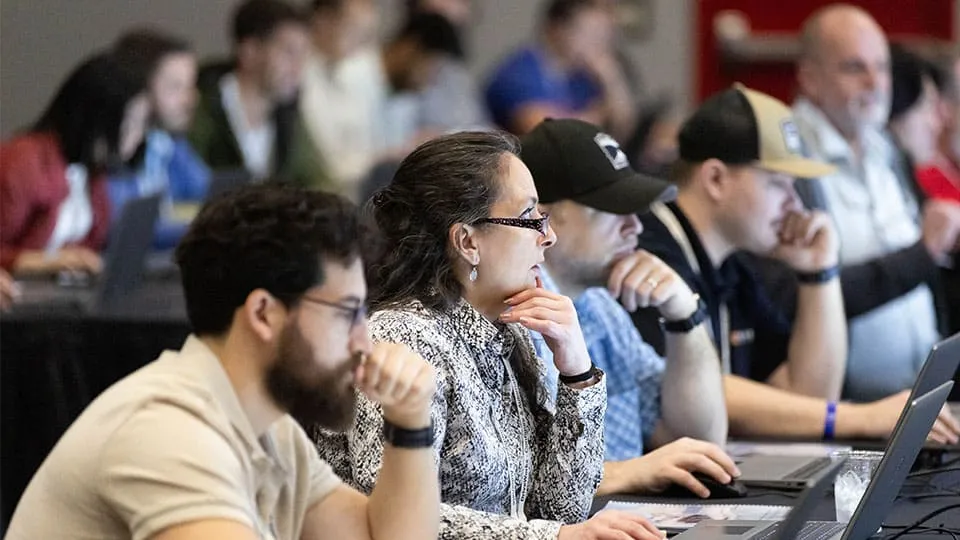 3DEXPERIENCE World 2025 attendees working on computers in a learning session