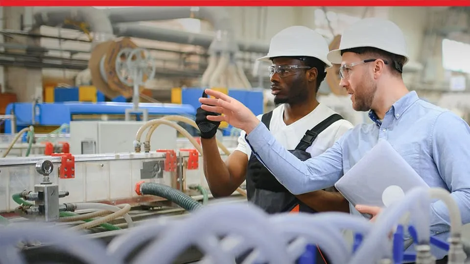 Two workers in discussion on plant floor - SOLIDWORKS