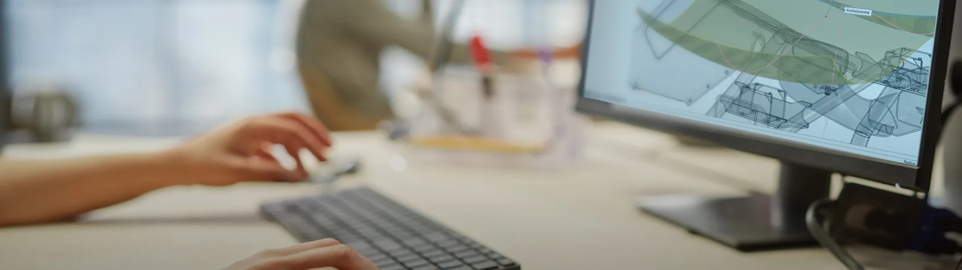 Hands on keyboard. 3D model on screen - SOLIDWORKS