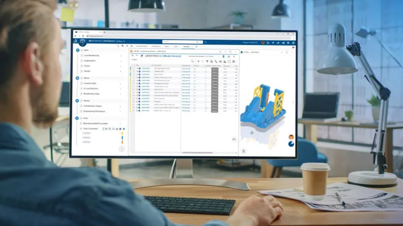Designer at monitor showing 3D model of part with design data - SOLIDWORKS