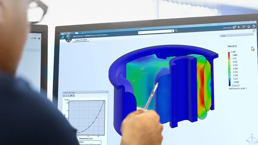 Engineer looking at screen with simulation data on 3D model of a part